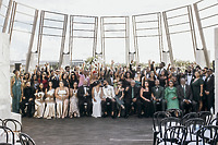Carina and Marvin's destination wedding party cheers outdoors, hands raised and smiling for the camera.