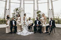 Carina and Marvin pose at the center indoors during their wedding, surrounded by bridesmaids and groomsmen.