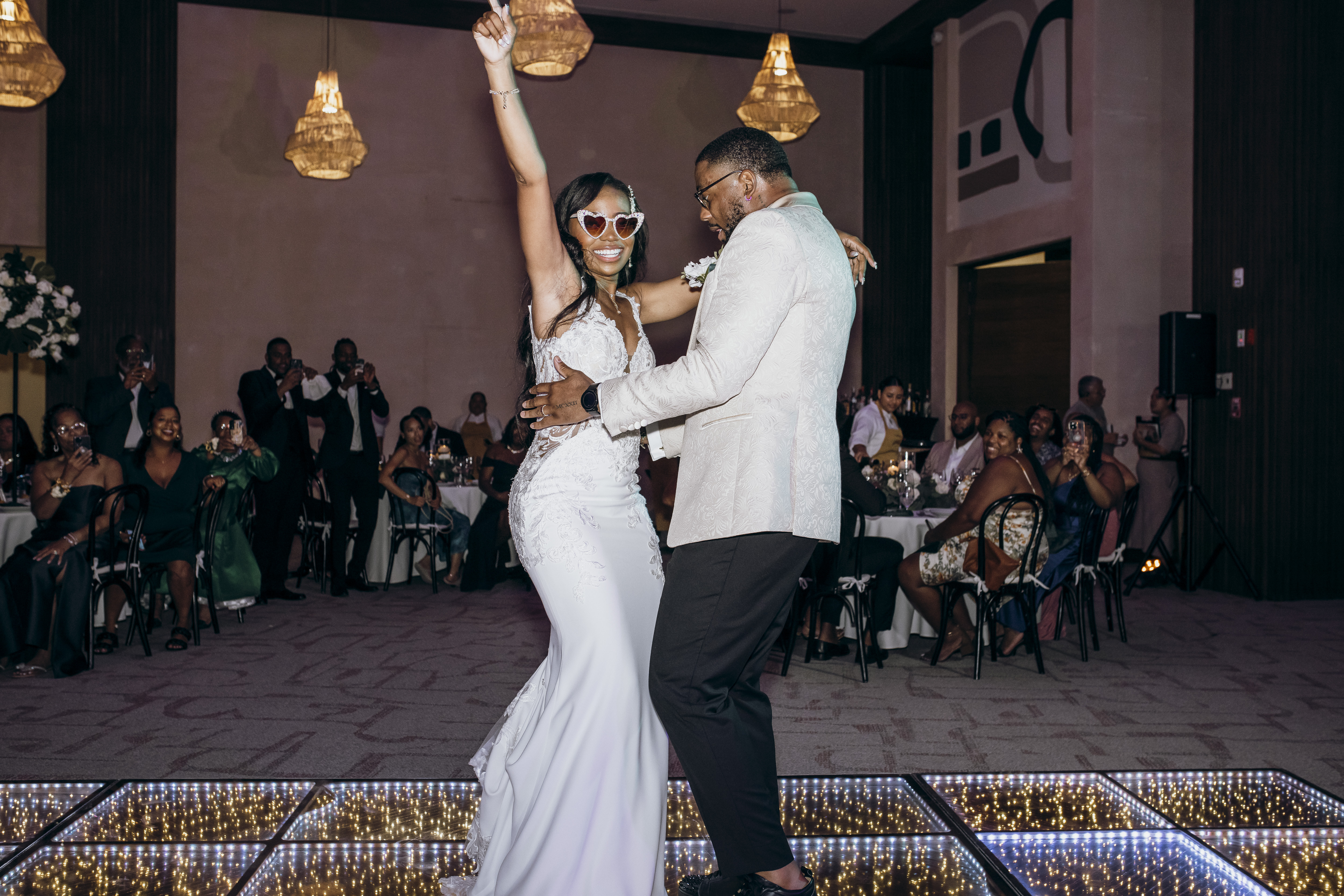 Carina and Marvin dance together on a glowing floor at their destination wedding reception.