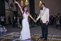Carina and Marvin hold hands on a glowing dance floor at their elegant destination wedding reception.
