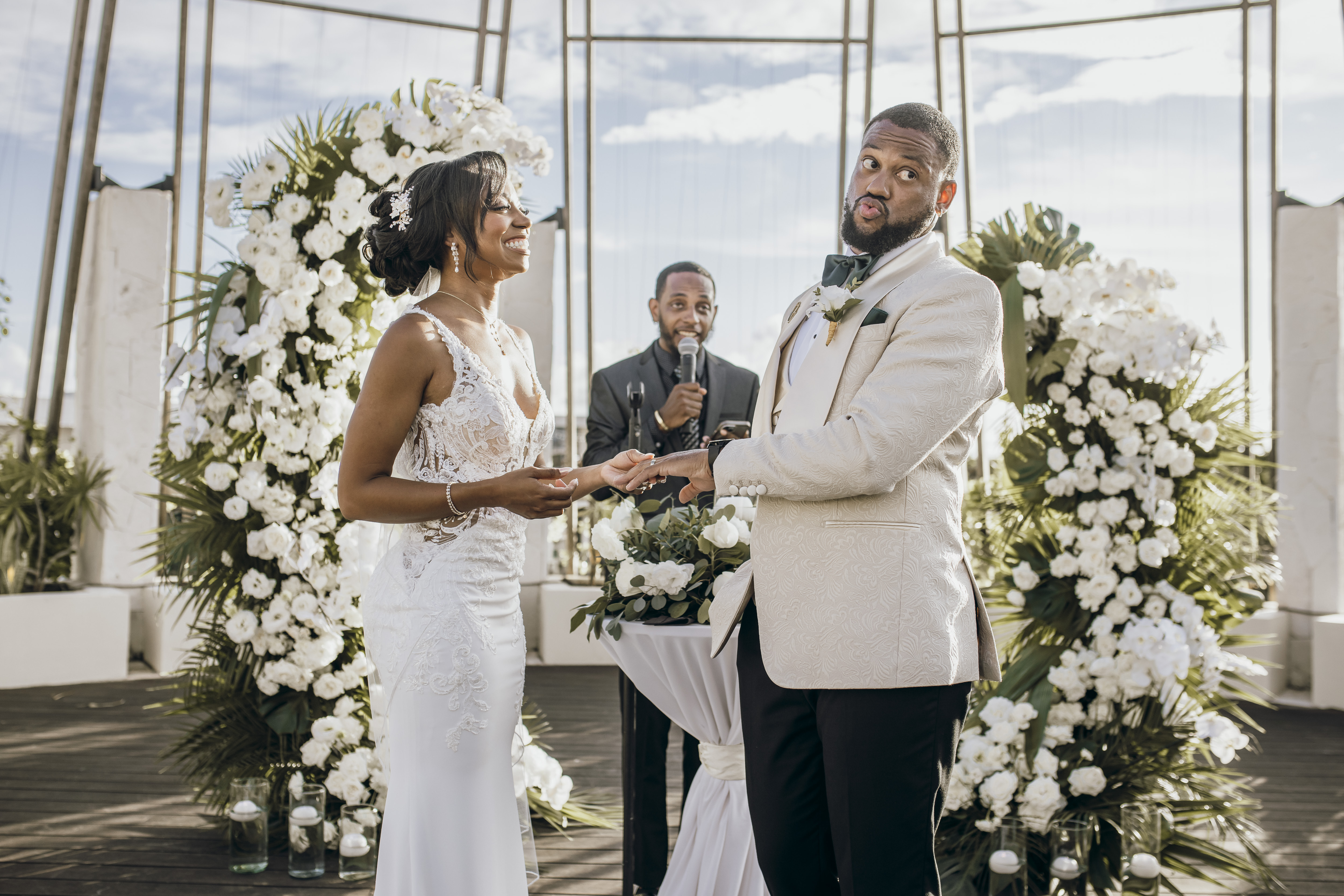 Carina and Marvin exchange rings at their destination wedding, surrounded by vibrant floral arrangements.
