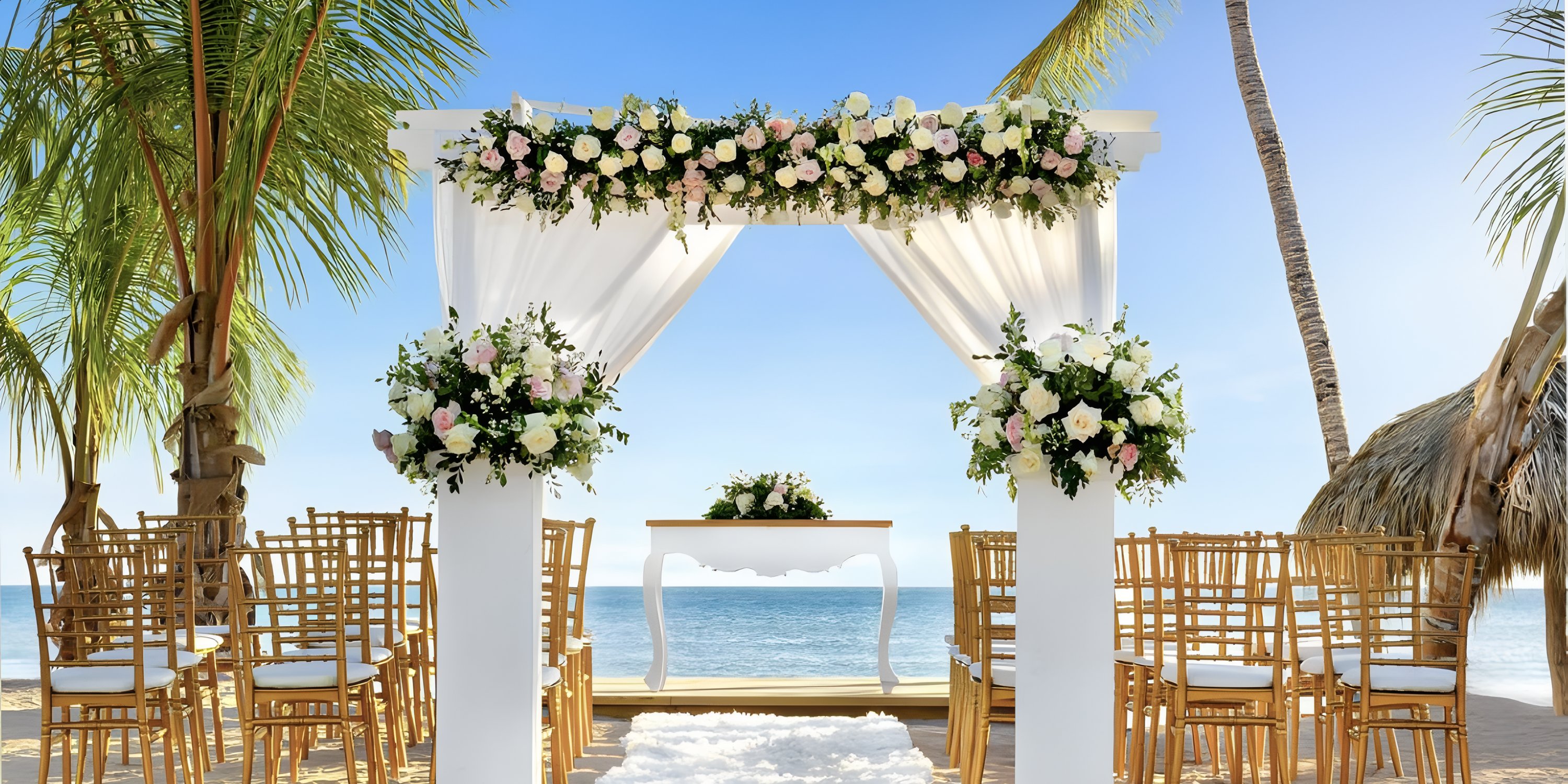 Sunscape Coco Punta Cana: destination wedding altar by the ocean with white drapery, flowers, and guest seating.