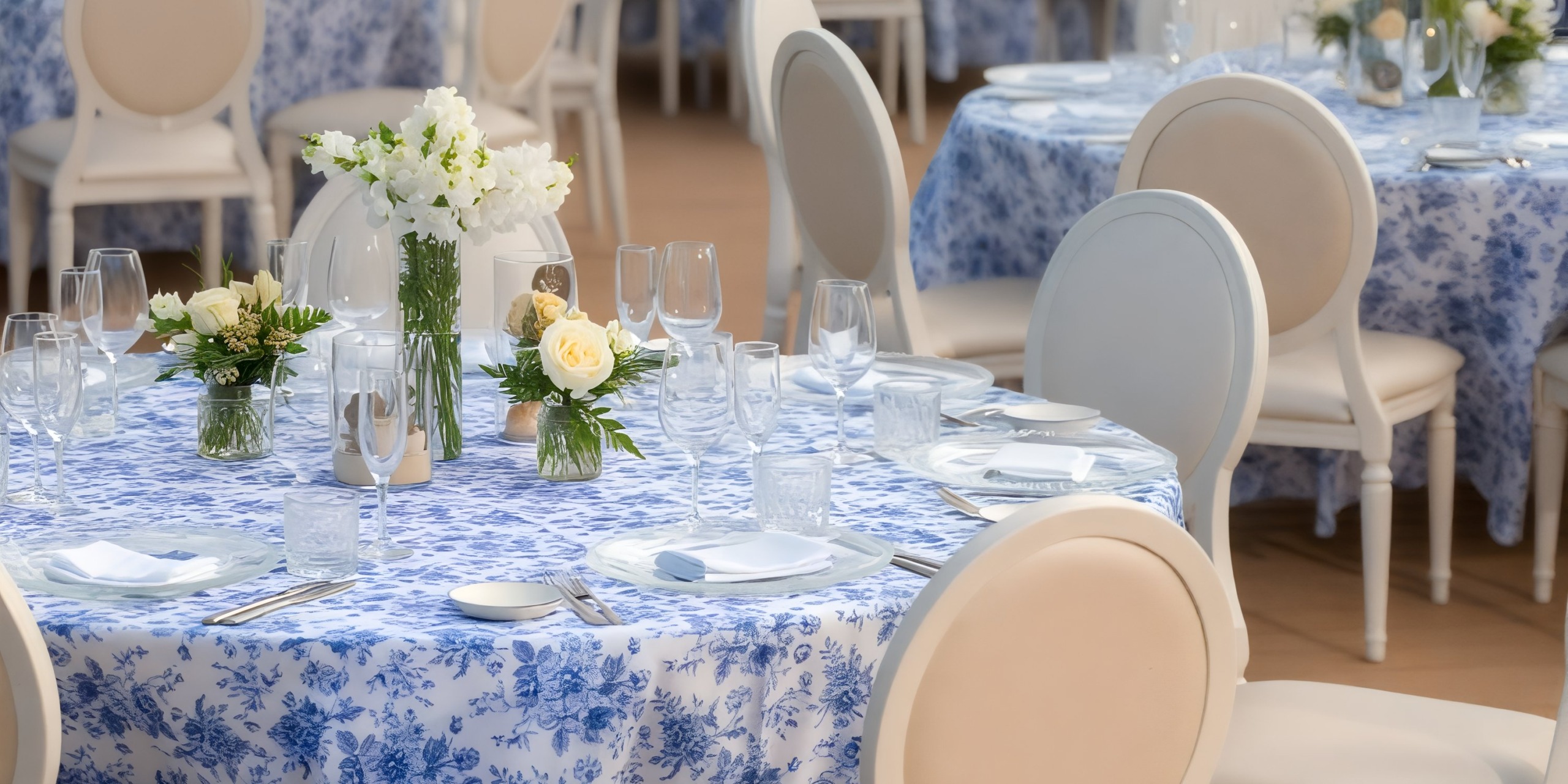 Dreams Cap Cana Resort's refined wedding setup: floral linens, elegantly arranged chairs, exquisite glassware, and beautiful flowers.
