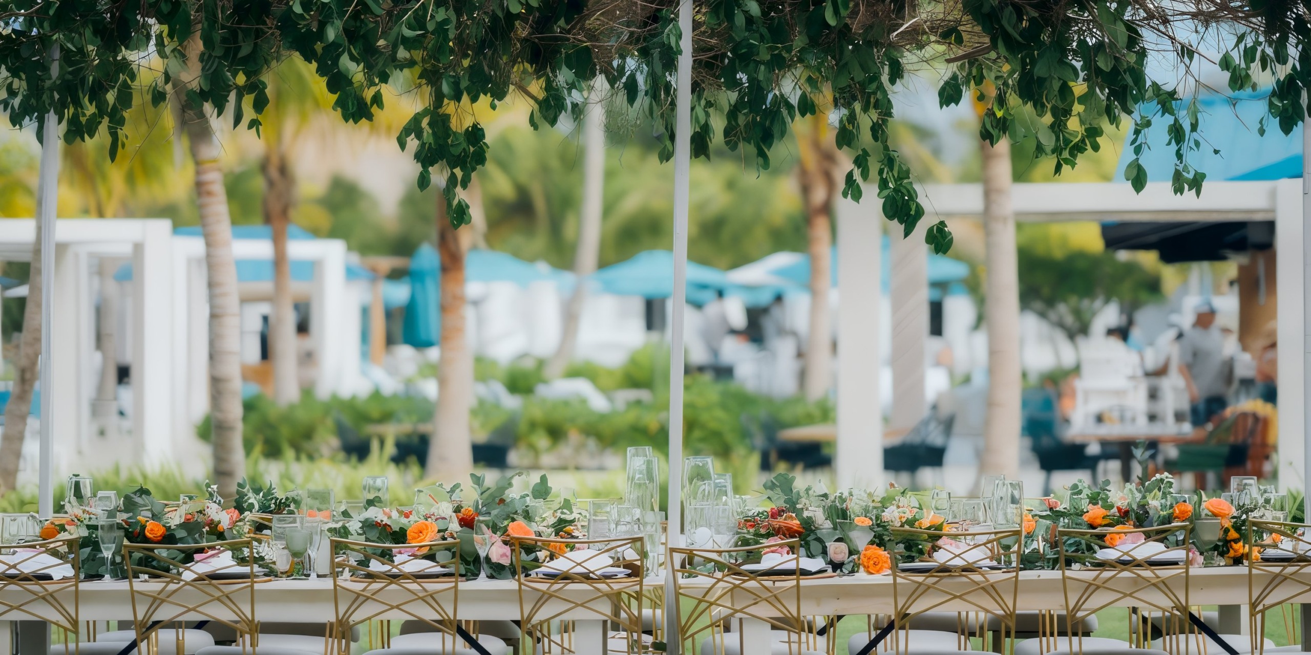 Experience the enchanting ambiance of outdoor dining at Dreams Cap Cana Resort & Spa, where beautifully decorated tables are set under lush greenery, creating an idyllic setting for your destination wedding.