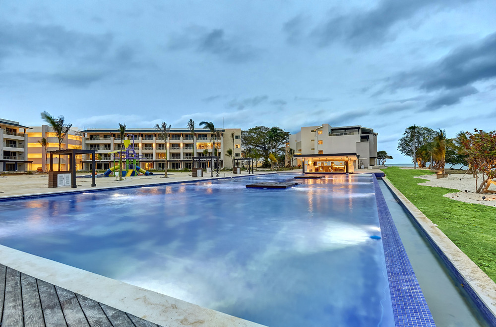 Spacious outdoor pool and lounge at a modern beachfront resort, perfect for a dream destination wedding.