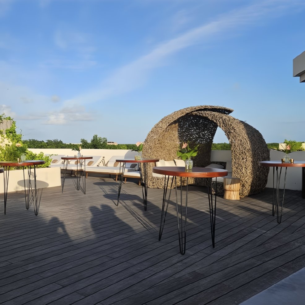 Rooftop patio with tall tables and woven lounge shade, perfect for a stylish destination wedding setting.