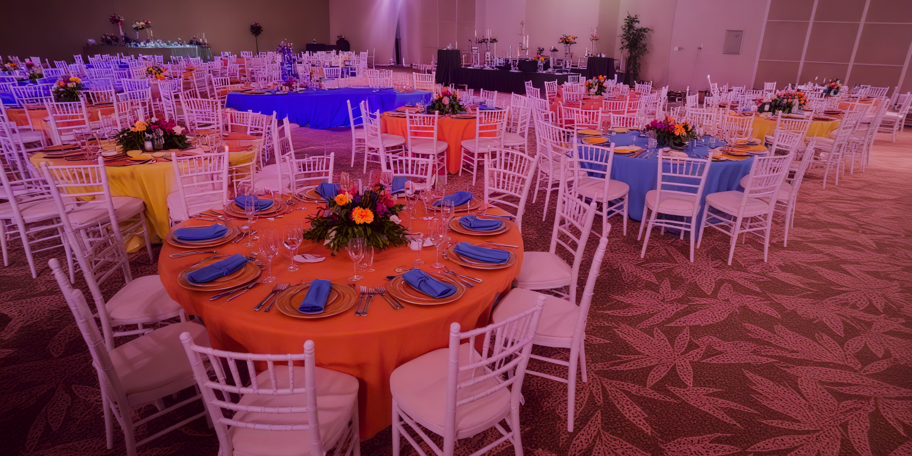 Elegant wedding banquet hall at Dreams Playa Esmeralda with vibrant tables and lush floral centerpieces.