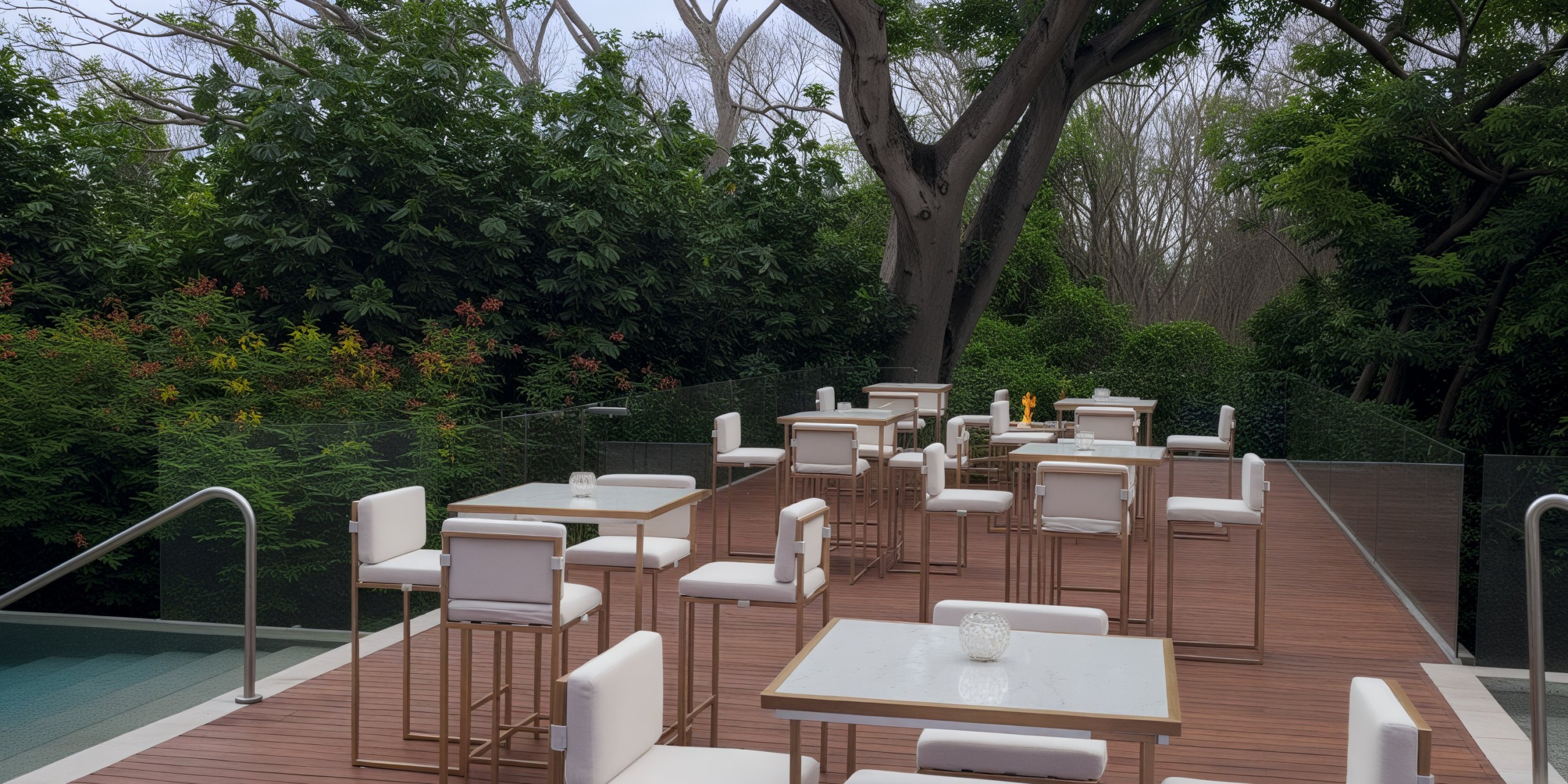 An outdoor seating area features white chairs and tables set on a wooden deck, nestled among trees, creating a picturesque setting ideal for a destination wedding.