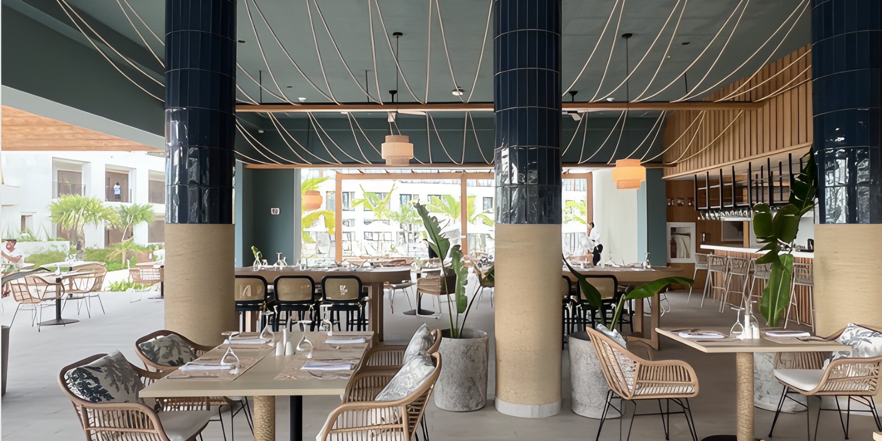 Secrets Playa Esmeralda displays wicker chairs, set tables, and large columns for a destination wedding.