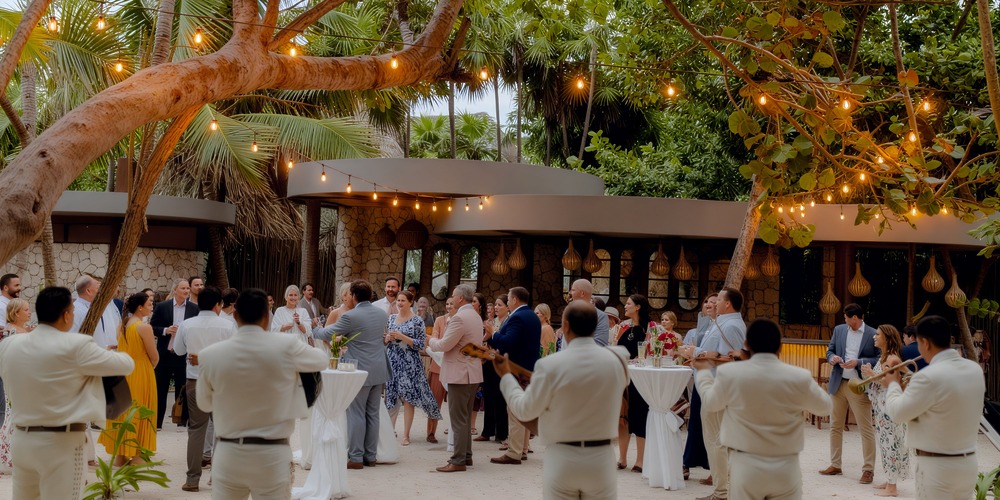 A destination wedding unfolds beneath a canopy of string lights, where guests mingle and musicians set the mood with their melodies.