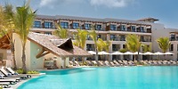Secrets Playa Esmeralda: resort pool with lounge chairs, umbrellas, palm trees—ideal for a destination wedding.