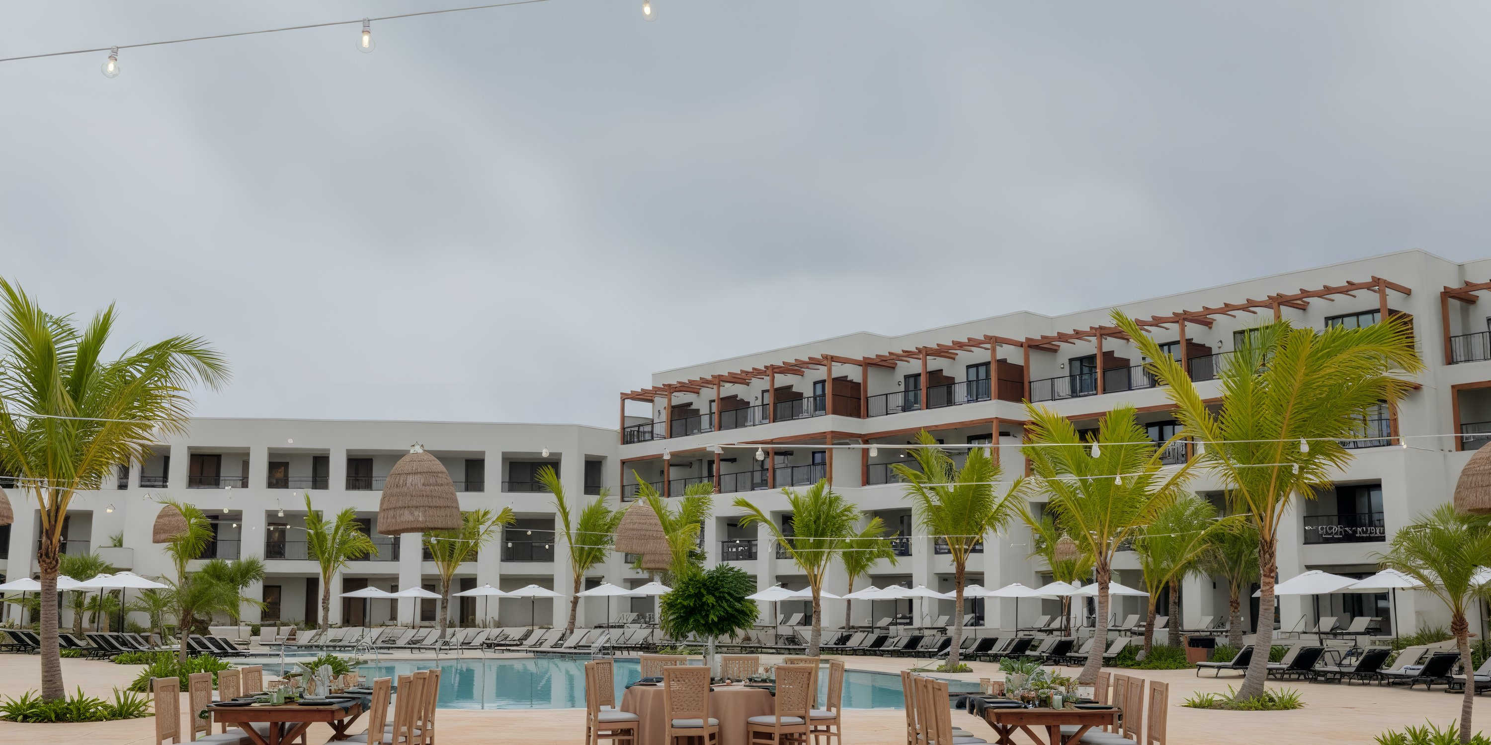 Outdoor pool at Secrets Playa Esmeralda, perfect for a destination wedding, with palms and lounge chairs.