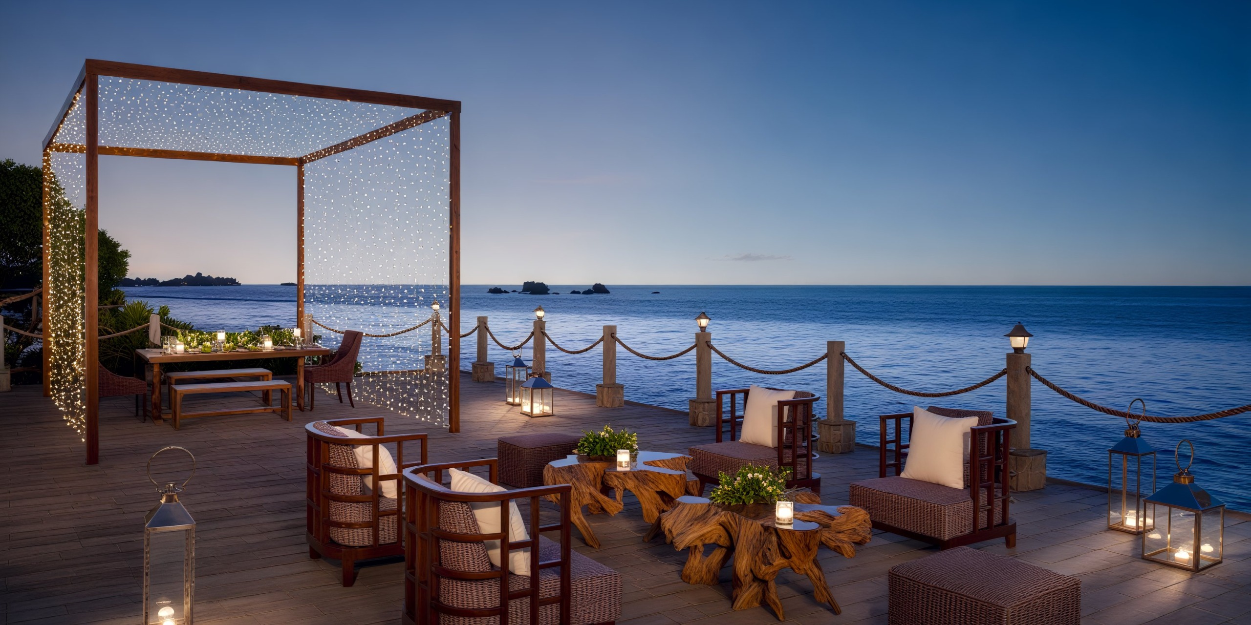 A charming outdoor dining area featuring wooden furniture offers a breathtaking sea view at sunset, creating the perfect setting for a destination wedding.