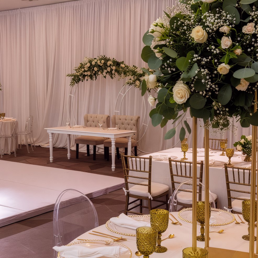 A sophisticated destination wedding reception featuring beautifully arranged floral decorations and elegantly set dining tables.