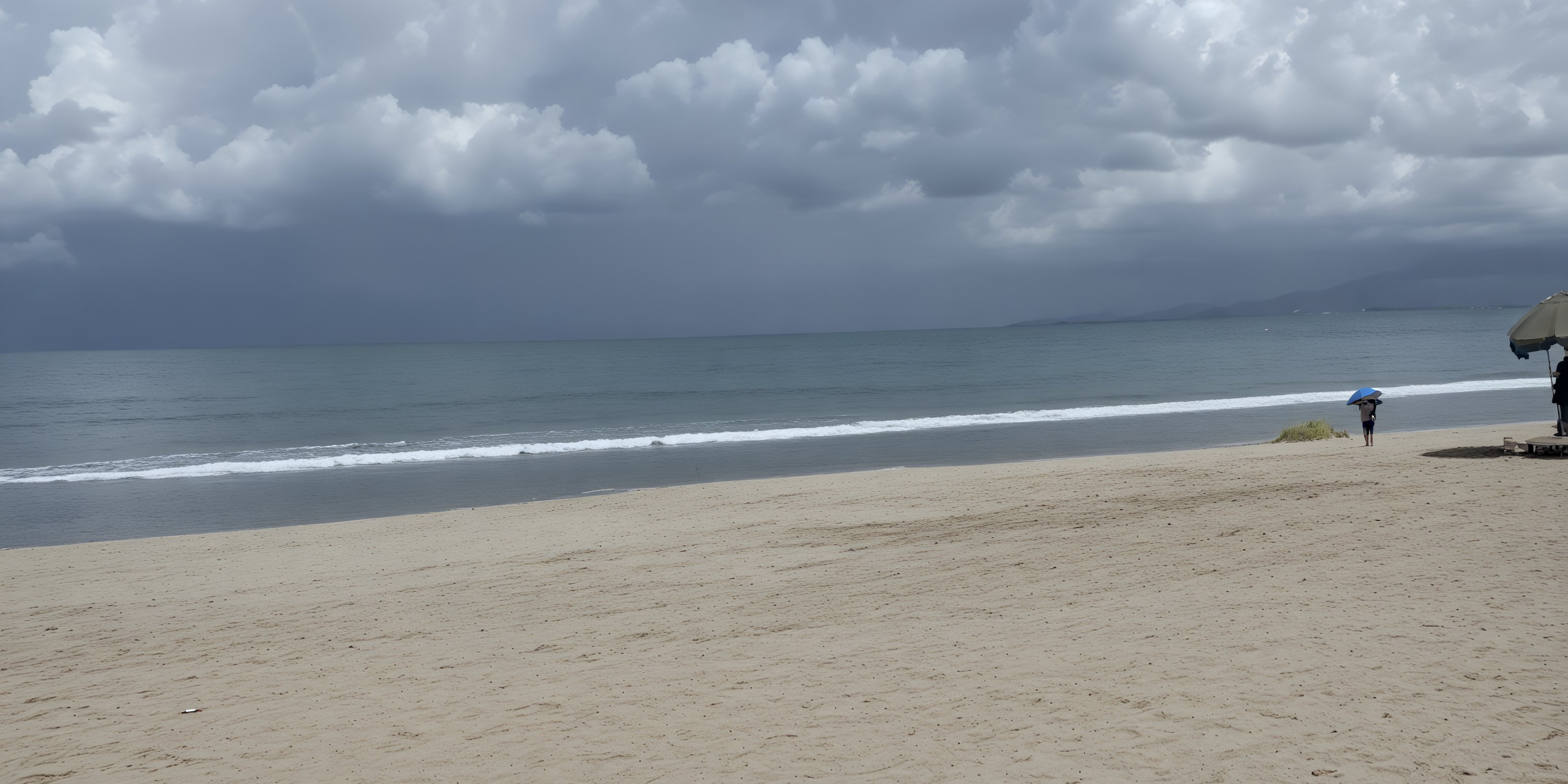Cloudy sky above a sandy beach at UNICO 20°105°, ideal for a destination wedding, one person, umbrella.