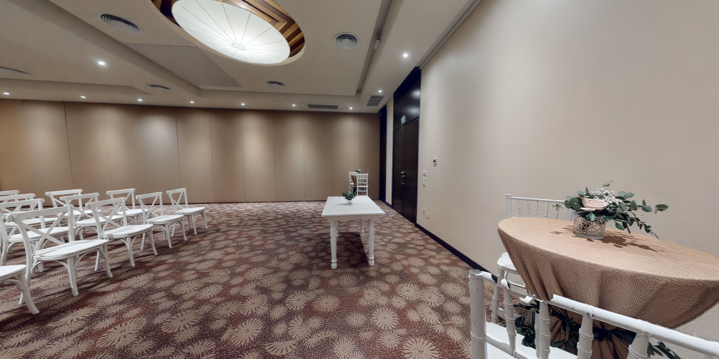 A vacant conference room with chairs and tables arranged, perfectly suited for a destination wedding setup.