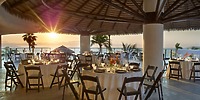 Round tables arranged for a destination wedding under a thatched roof at UNICO 20&deg;105&deg; Riviera Nayarit.