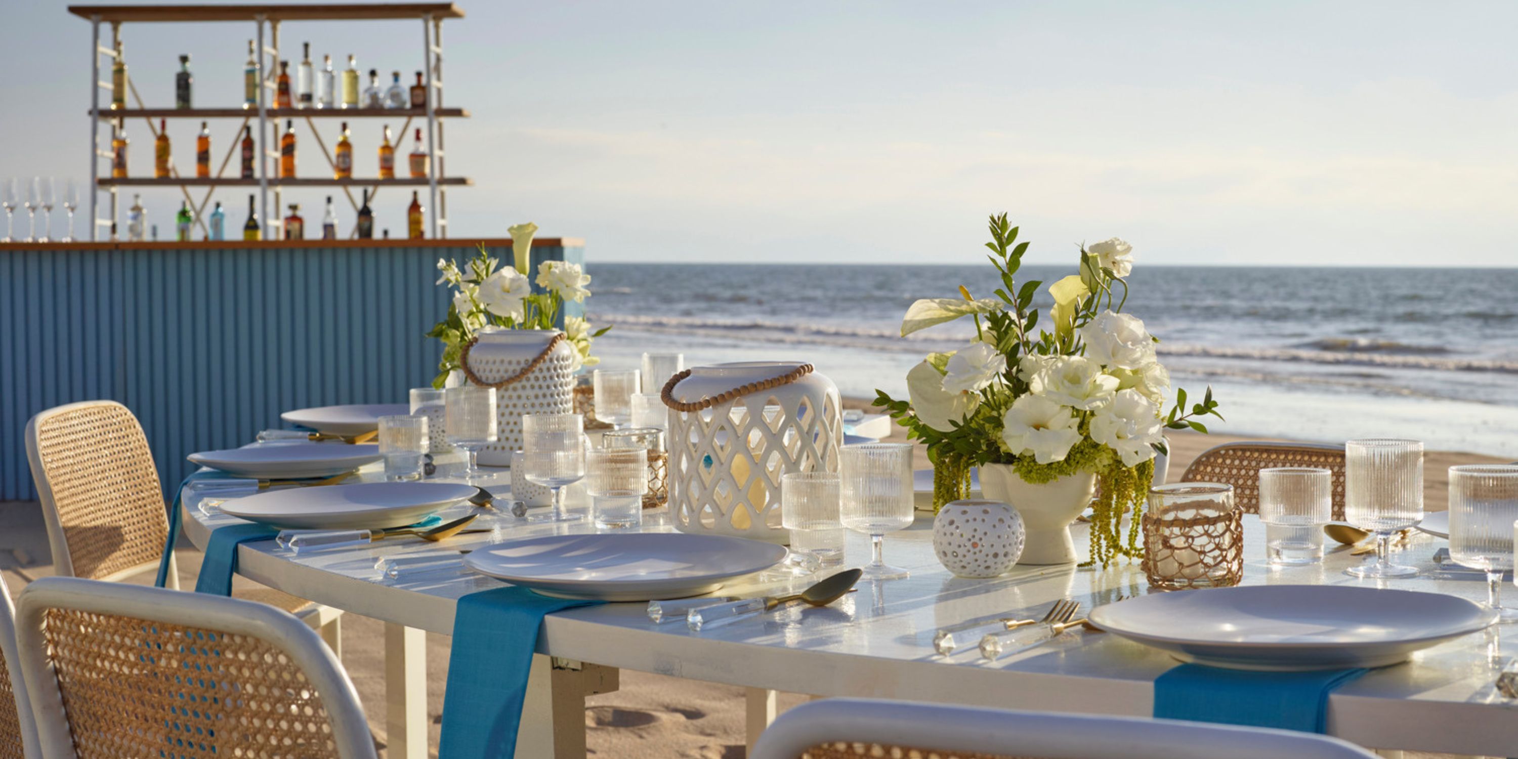 Elegant wedding dining setup on the beach at UNICO 20°105° Riviera Nayarit, with flowers and a bar.