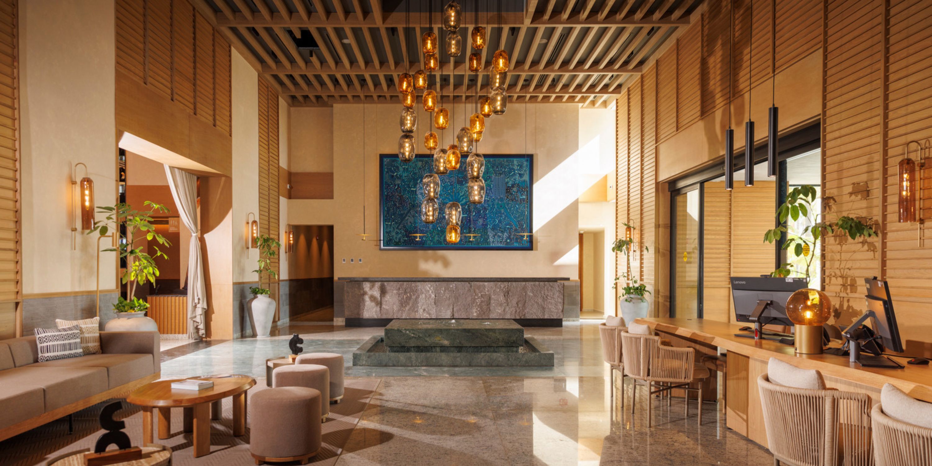 Modern lobby at UNICO 20&deg;105&deg; Riviera Nayarit, ideal for destination wedding guests, with seating and chandelier.