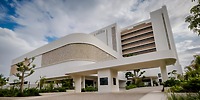 Modern white UNICO 20°105° Riviera Nayarit, perfect for a destination wedding, with curved entrance and lush landscaping.