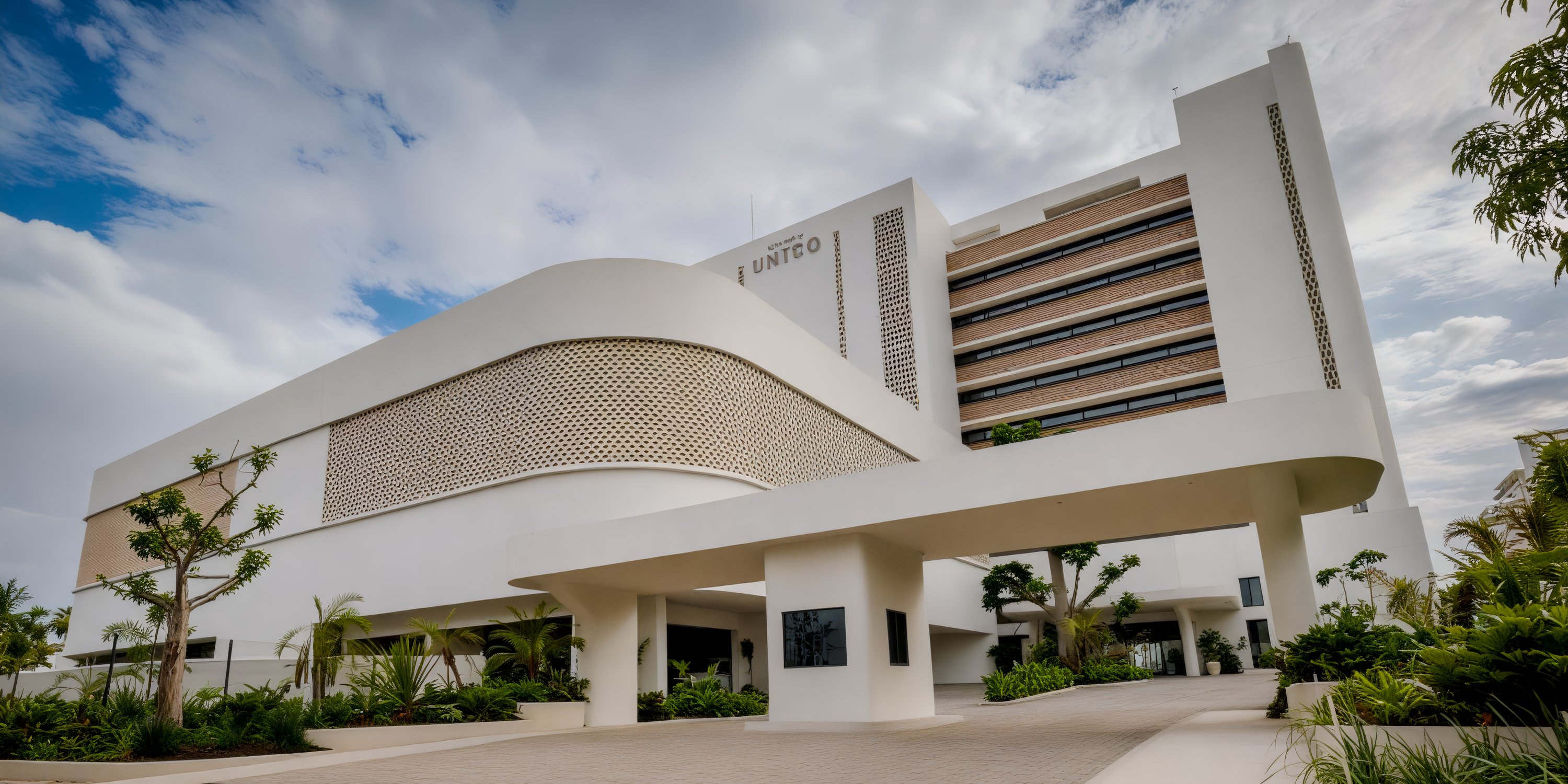 Modern white UNICO 20°105° Riviera Nayarit, perfect for a destination wedding, with curved entrance and lush landscaping.
