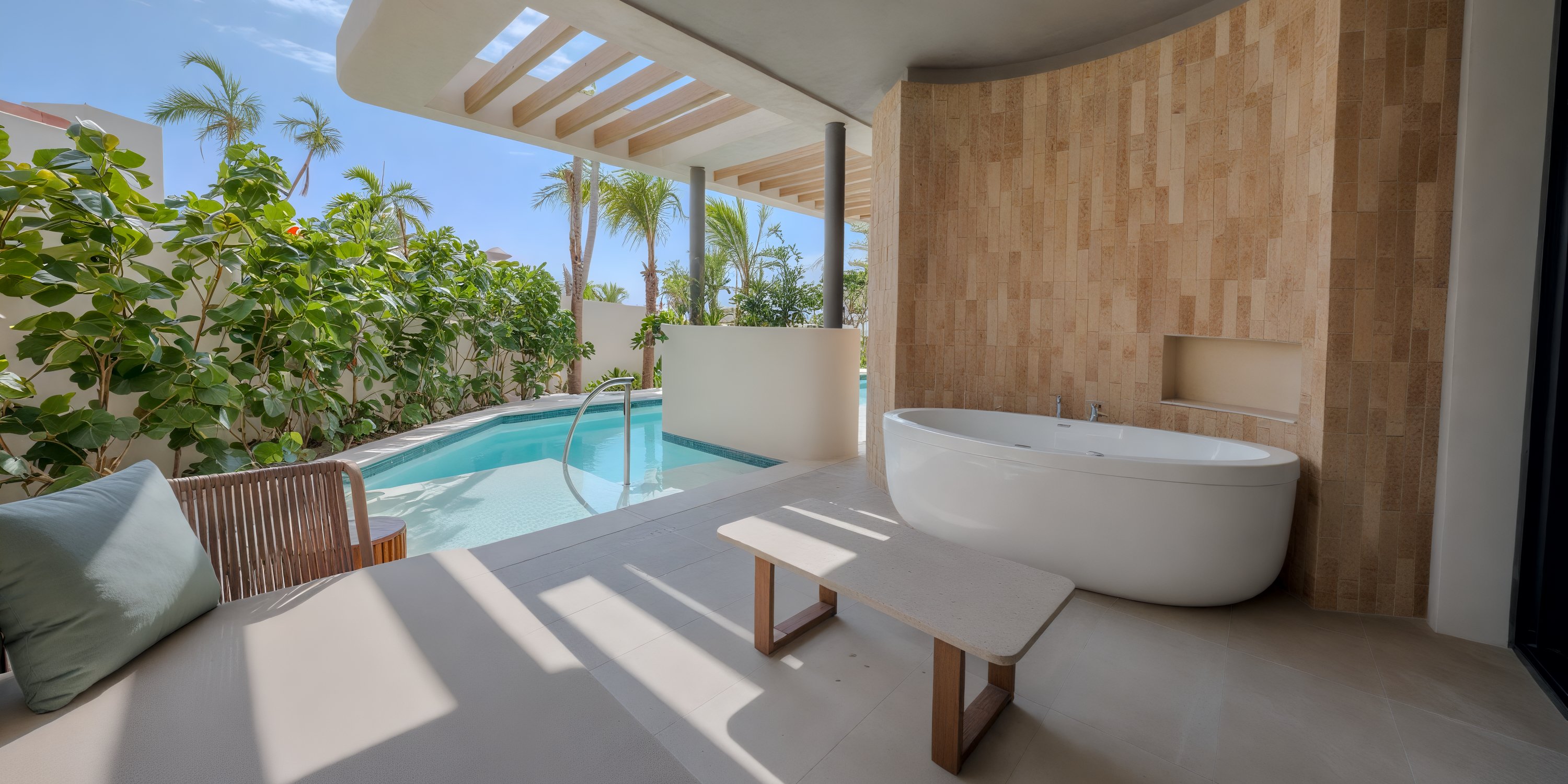 Modern patio perfect for a destination wedding: bathtub, small pool, wood seating, tropical plants.