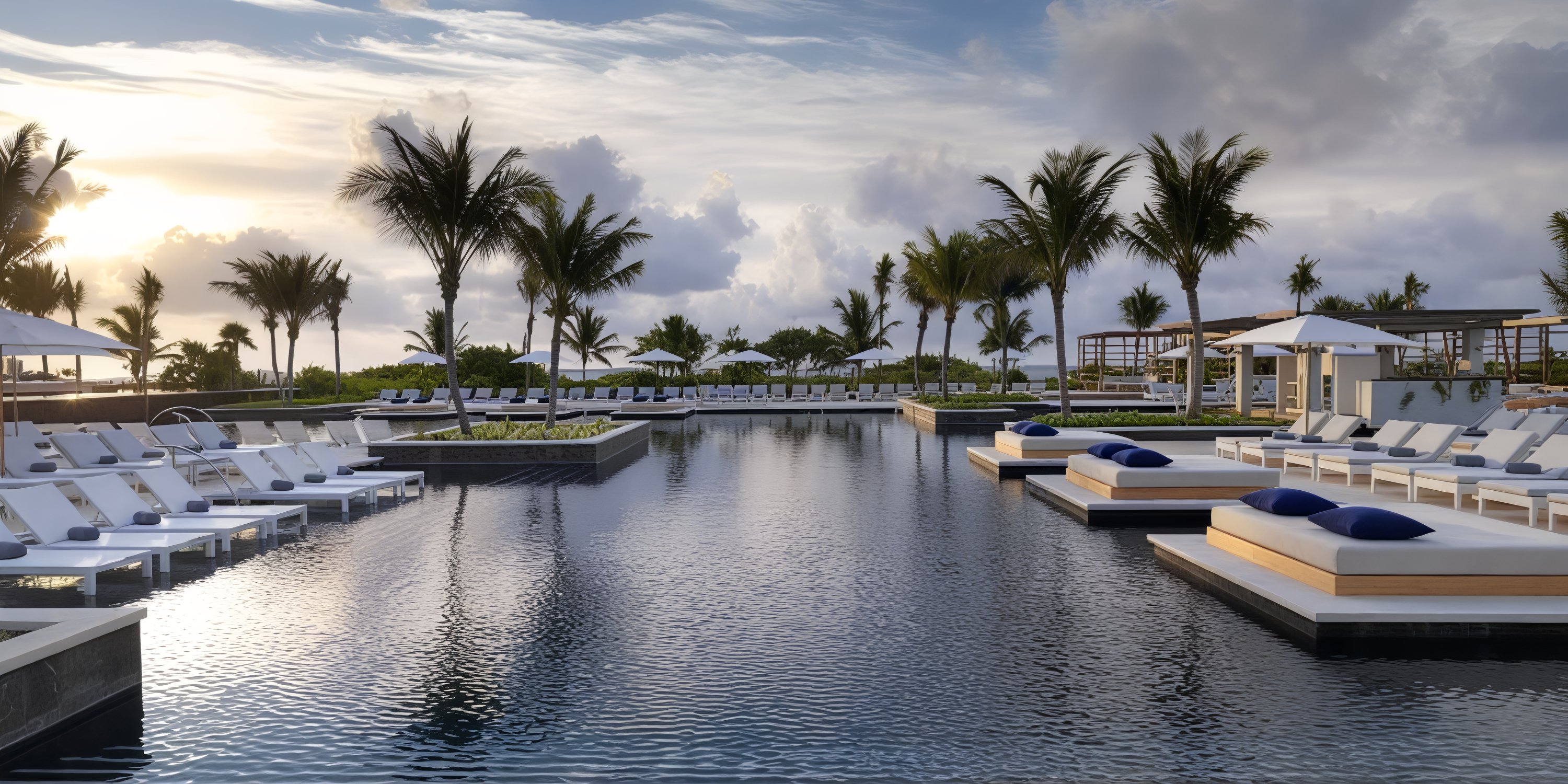 UNICO 20°87°: As the sun sets, imagine saying "I do" amidst the serene backdrop of poolside lounge chairs, umbrellas, and swaying palm trees—an idyllic scene for your destination wedding.