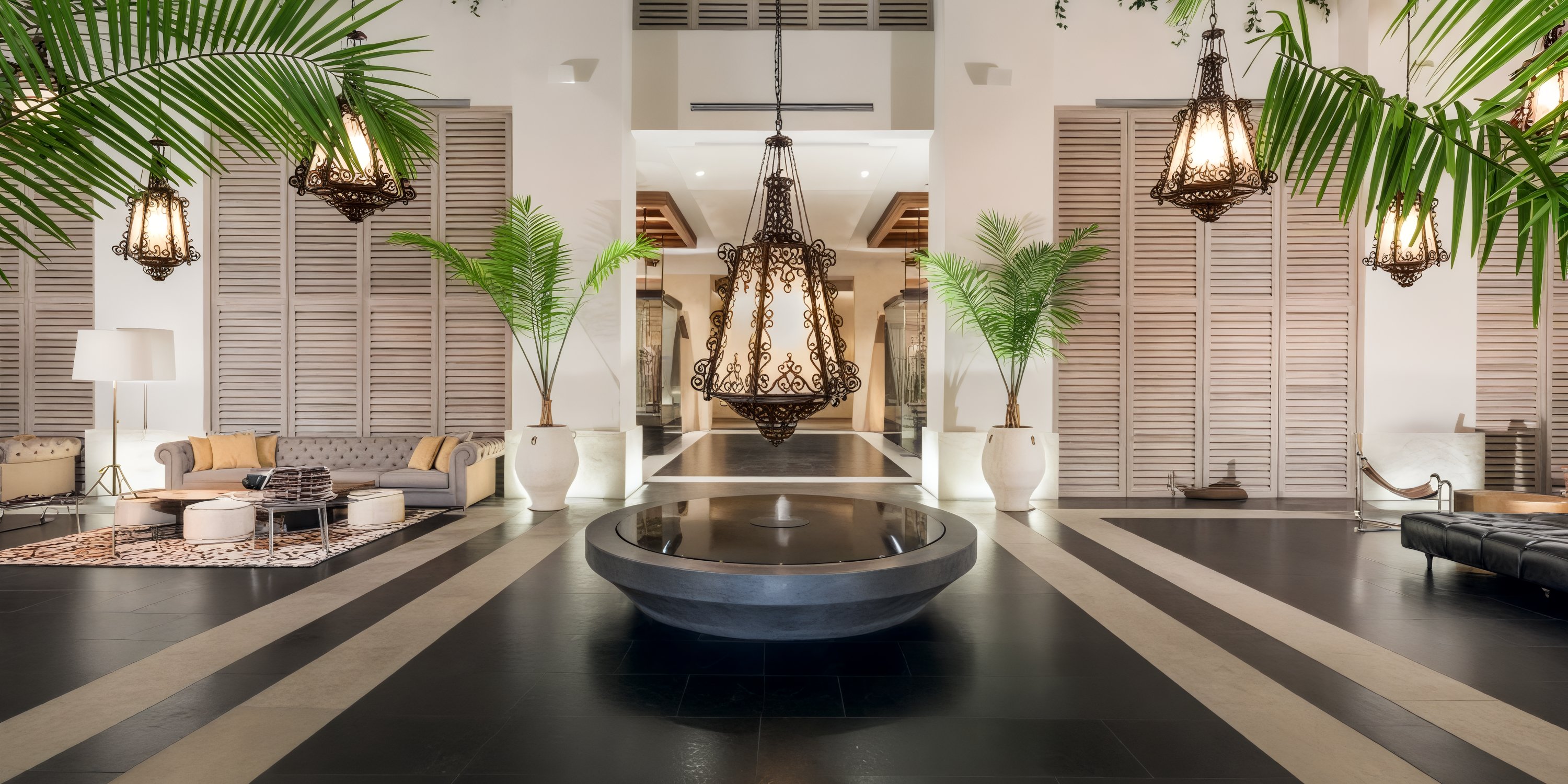 UNICO 20°87° boasts a spacious lobby, perfect for hosting wedding celebrations. Adorned with modern seating, a stunning chandelier, and elegant potted palms, it provides an inviting atmosphere for the perfect destination wedding.