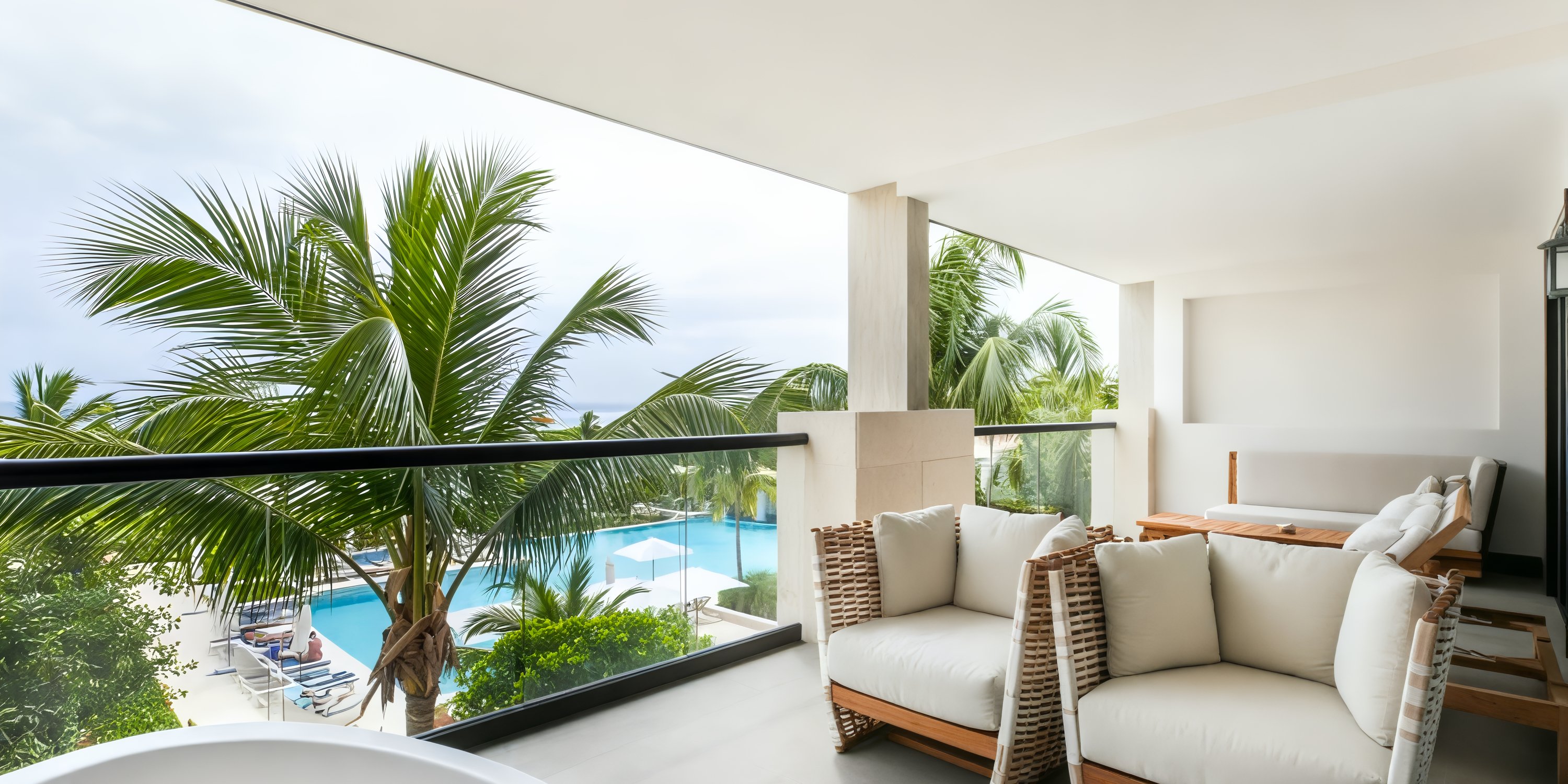 Balcony at UNICO 20°87°, offering chairs with views of the pool and palm trees—perfect for a destination wedding setting.