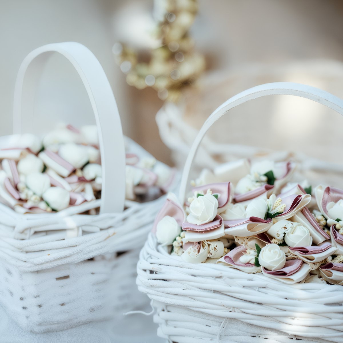 Two white baskets filled with fabric flowers—ideal as charming favors for your destination wedding.