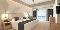 Enjoy a romantic stay in the Hotel Riu Ventura’s spacious room featuring a large bed, elegant wooden furnishings, and a private balcony with breathtaking ocean views—perfect for your wedding night or as an idyllic retreat during your destination wedding celebration.