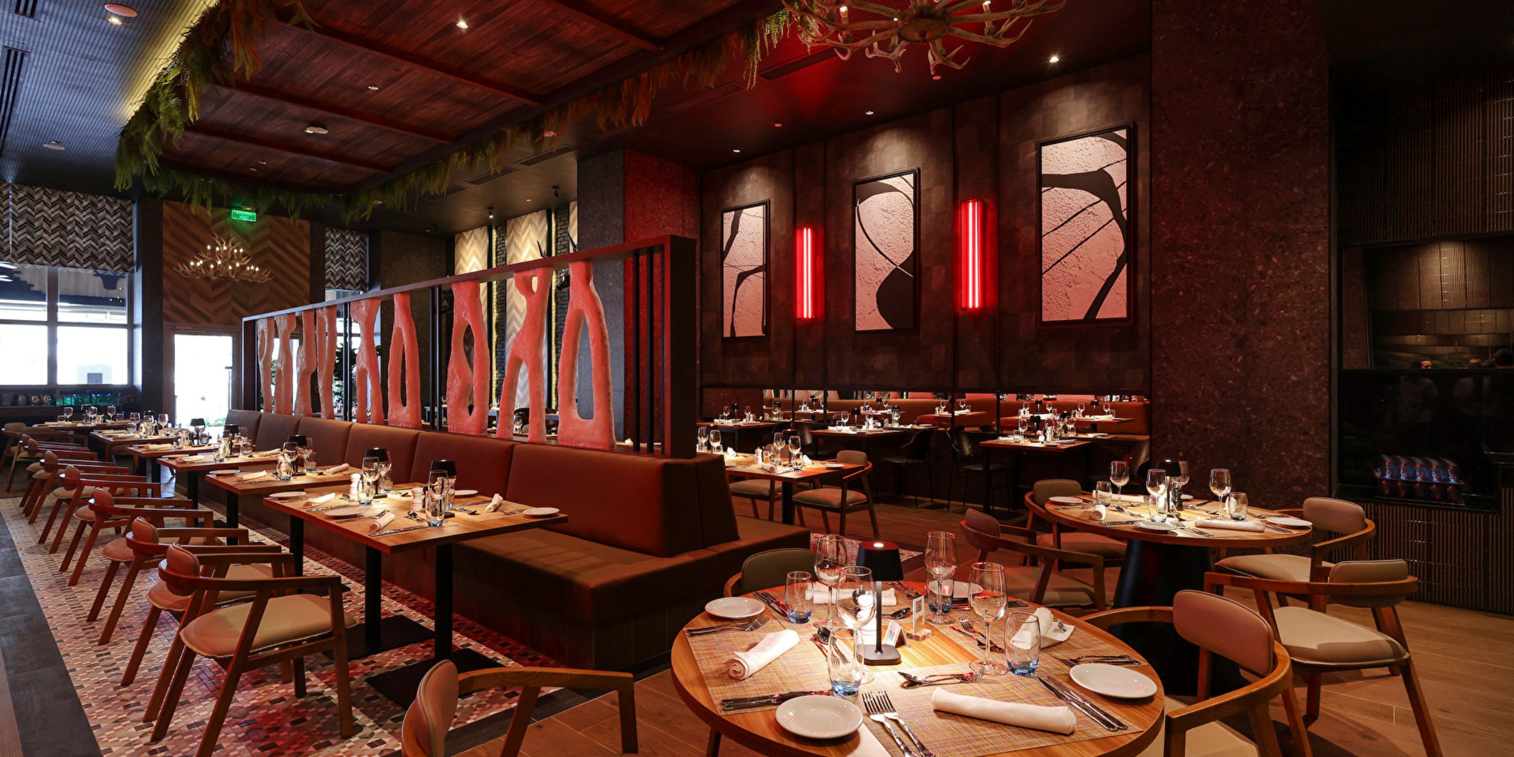 Hotel Riu Ventura offers a stylish destination wedding setting with set tables and red-lit accent walls.