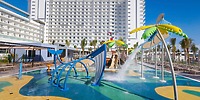Splash pad with vibrant water features in front of Hotel Riu Ventura, a fun spot for destination weddings.