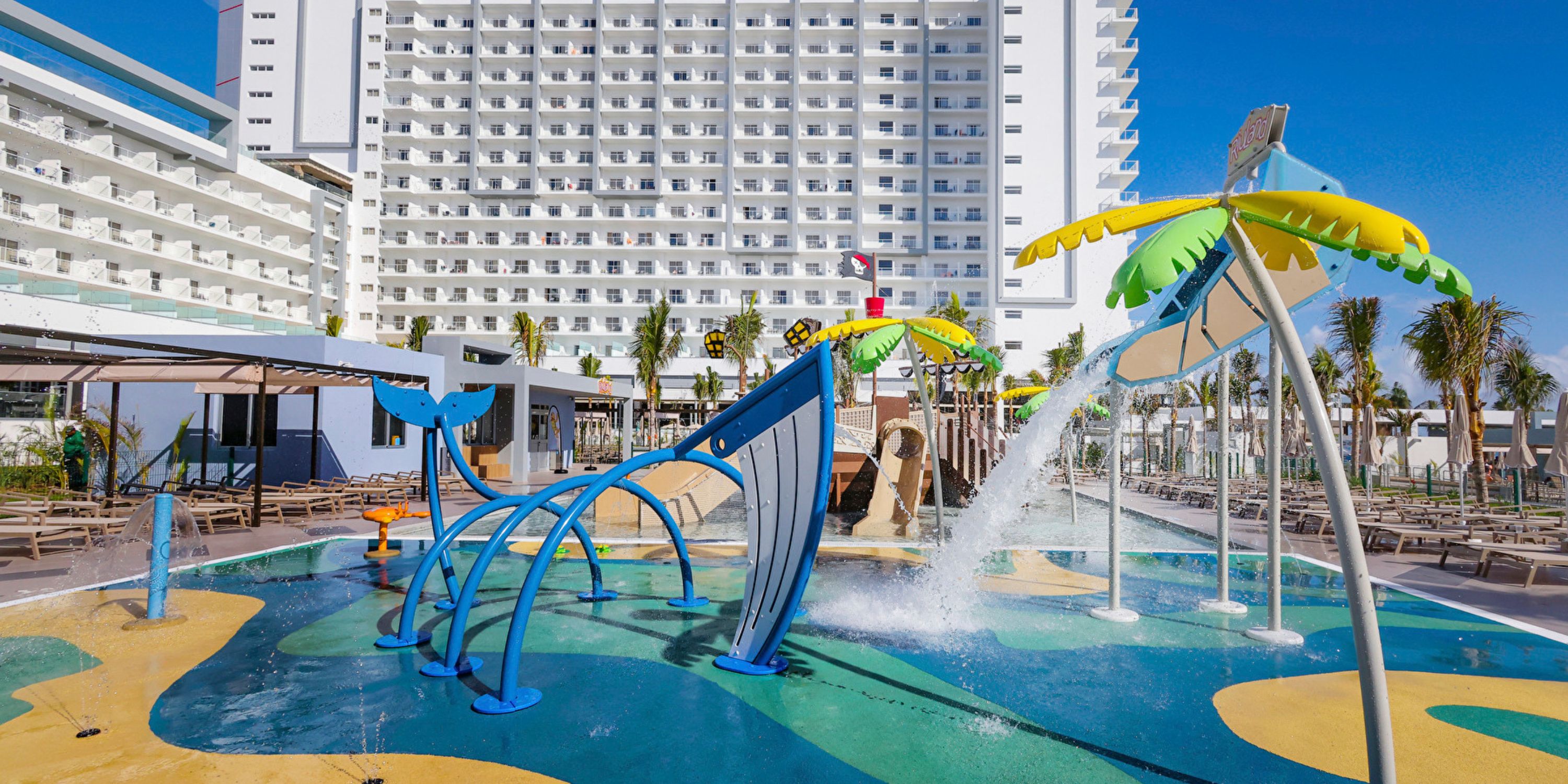 Splash pad with vibrant water features in front of Hotel Riu Ventura, a fun spot for destination weddings.