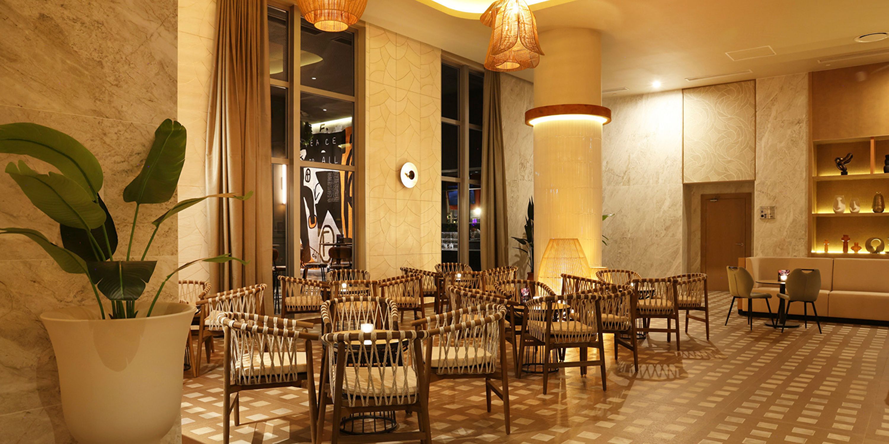Hotel Riu Ventura lounge, ideal for a destination wedding, with wicker chairs, round tables, and marble walls.