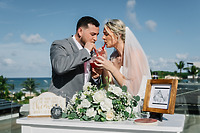 Carina and Steven share a toast at their romantic destination wedding by the ocean.