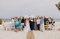 Wedding guests at Ashleigh and Dominic's destination wedding raise their glasses in joyful celebration.
