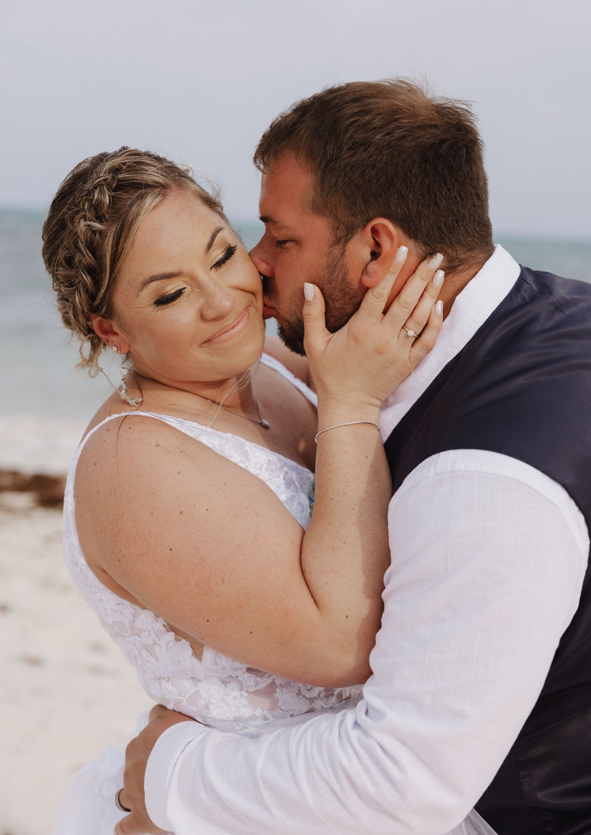 Ashleigh and Dominic share a joyful moment during their beautiful destination wedding on the beach.