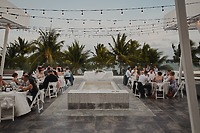 Nancy and David’s destination wedding featured guests seated at round tables beneath twinkling string lights, creating a magical outdoor celebration.