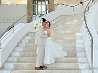 Ashleigh and Dominic share a loving embrace on a marble staircase, dressed in their elegant wedding attire at their beautiful destination wedding.