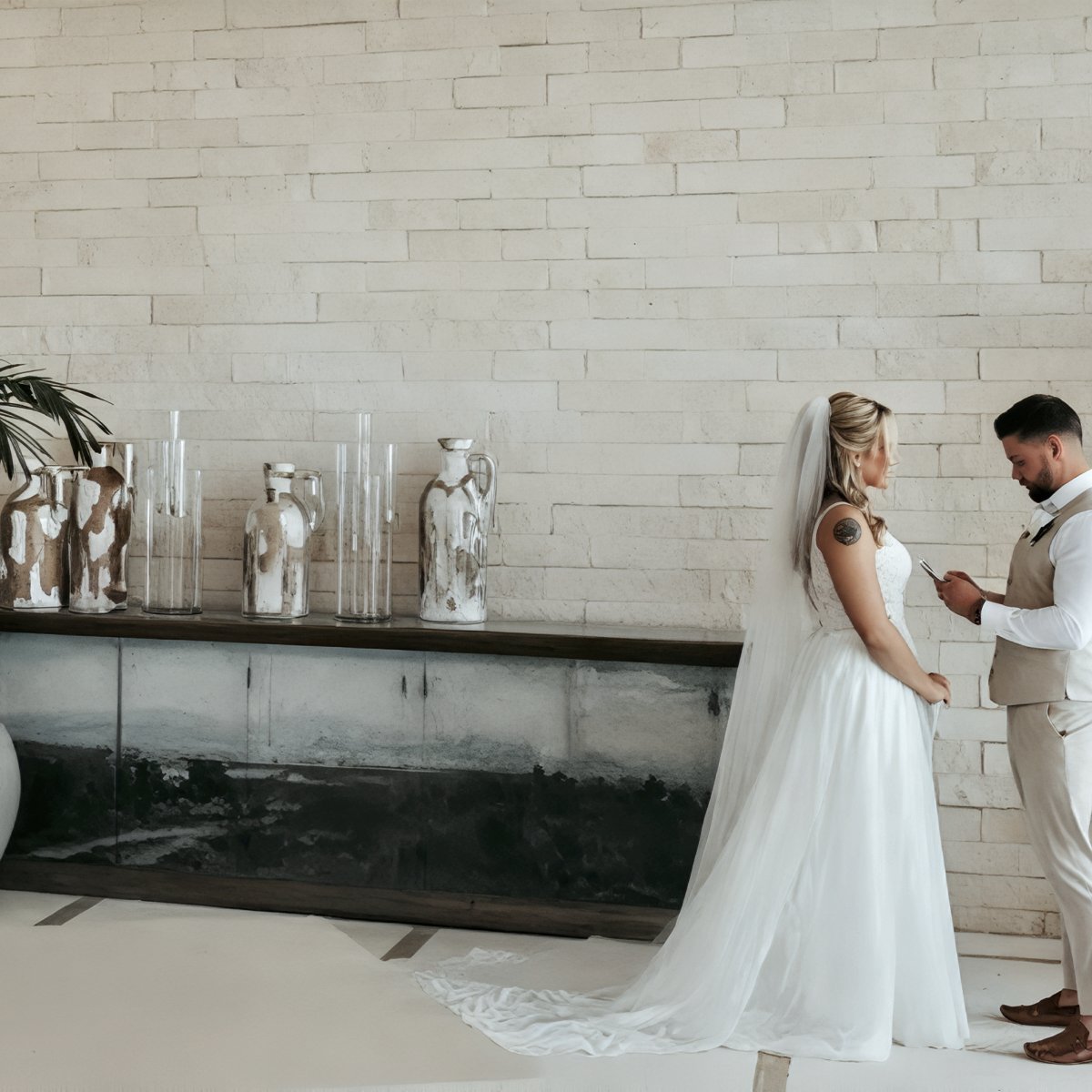 Emily and Stephen stand indoors at their destination wedding, as Stephen reads heartfelt words from a piece of paper.