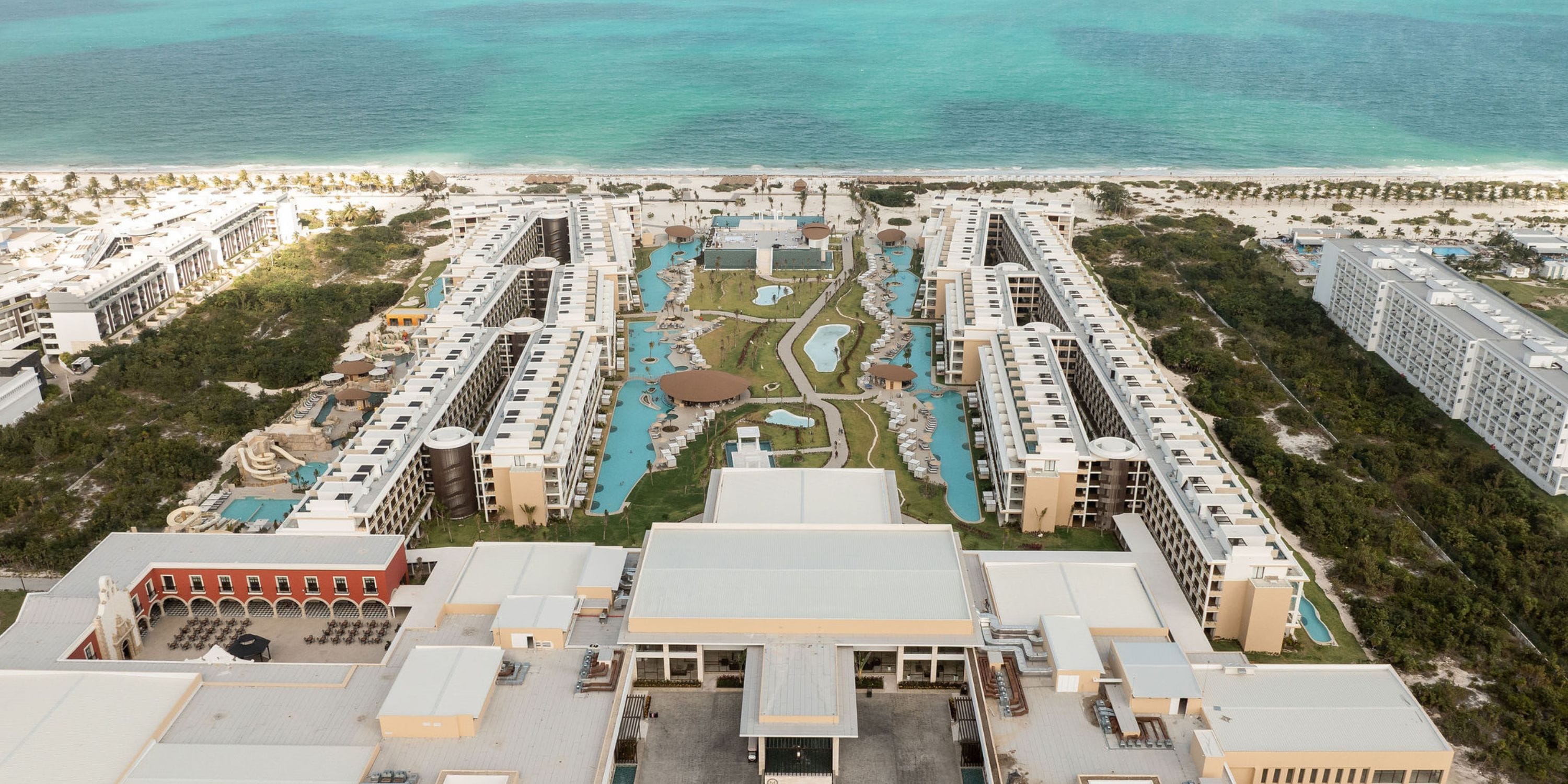 Aerial view of Majestic Mirage Costa Mujeres resort, an ideal destination wedding spot with pools, gardens, and beach access.