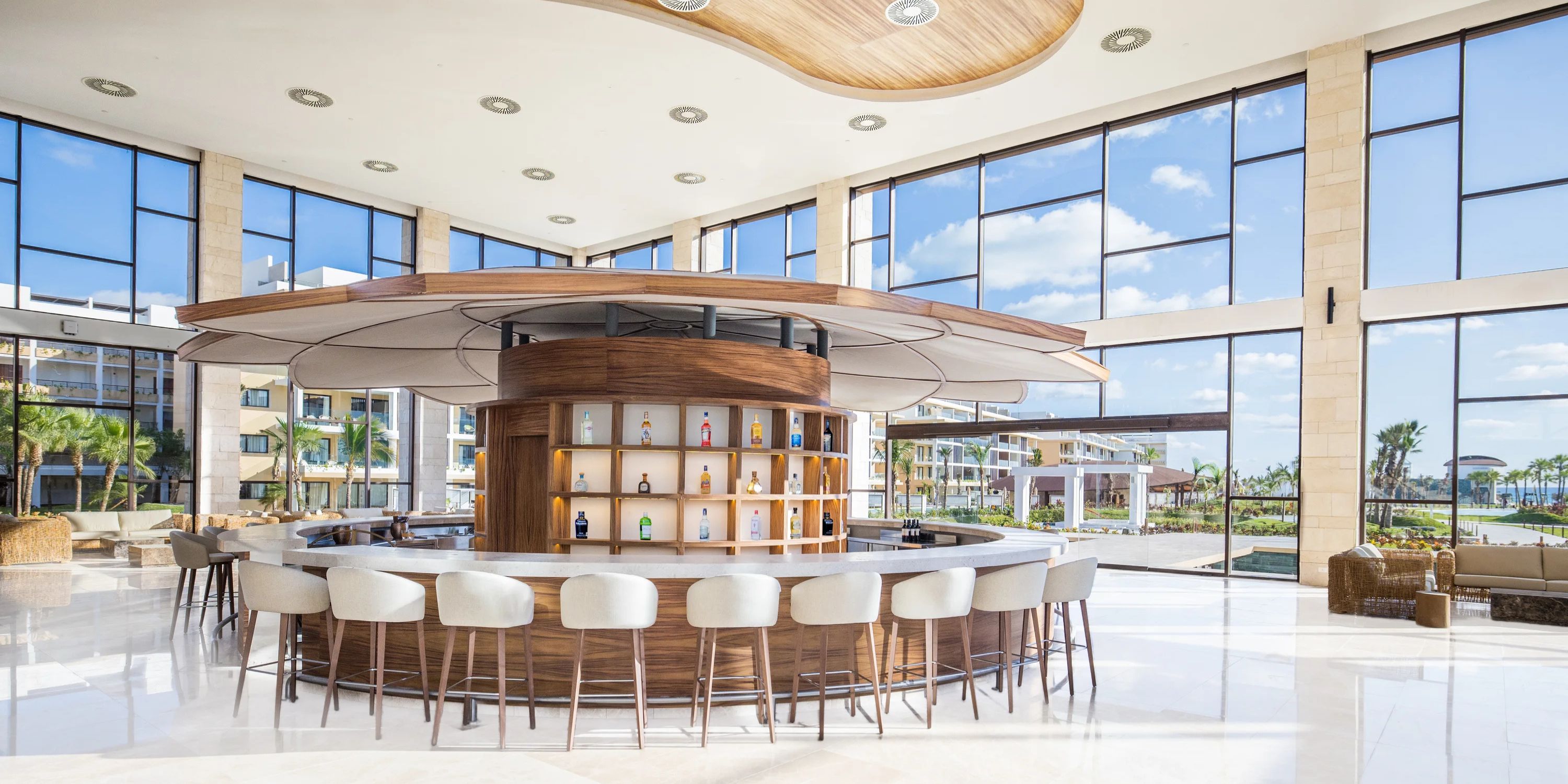 Circular bar with stools in a bright, airy lobby, perfect for a destination wedding at Majestic Mirage.