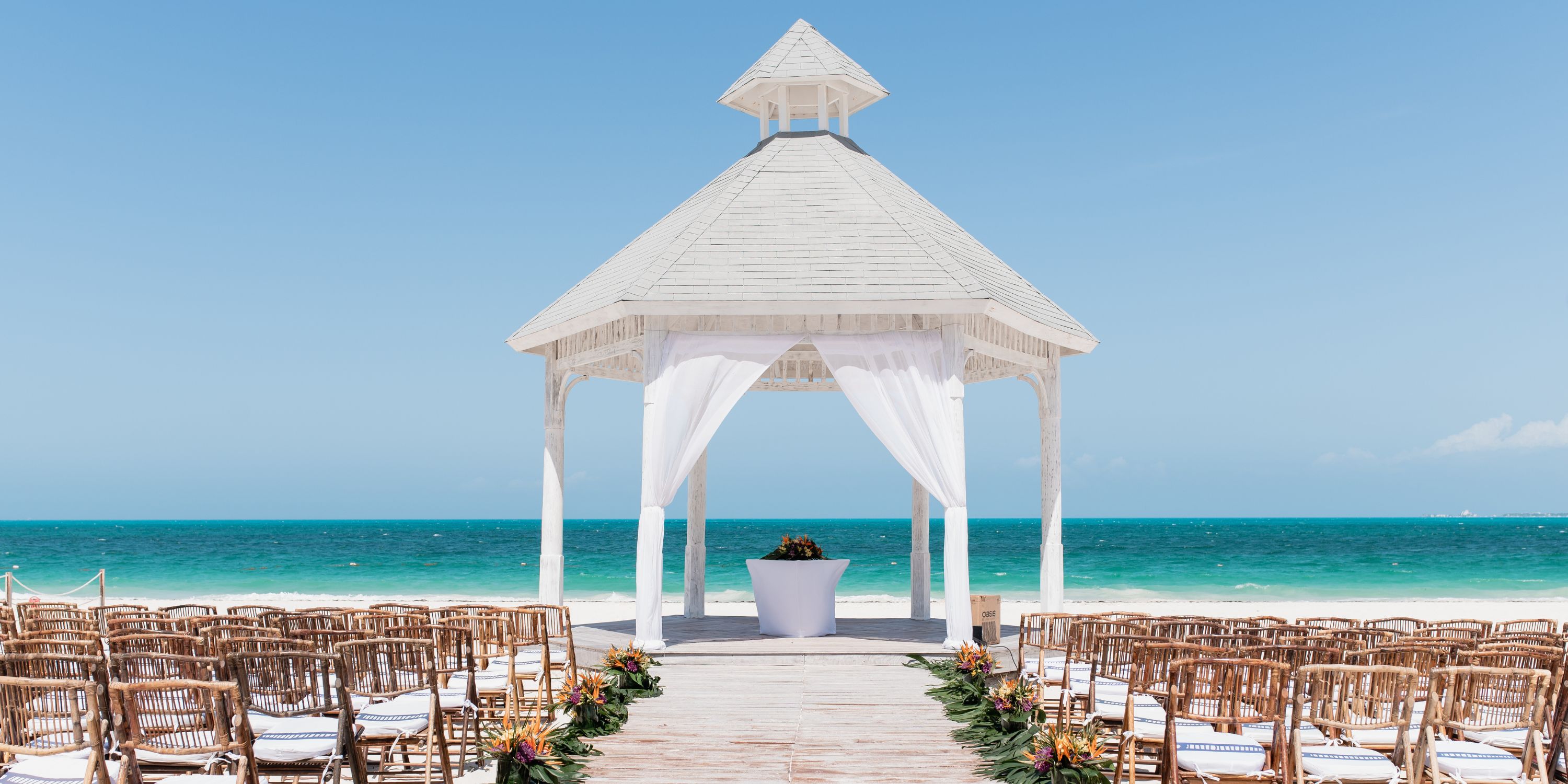 White gazebo prepared for a wedding on the beach, ideal for destination weddings at Majestic Mirage Costa Mujeres.