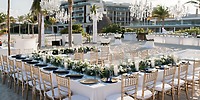 Destination wedding at Elegant Majestic Mirage Costa Mujeres, featuring white d&eacute;cor and gold chairs.