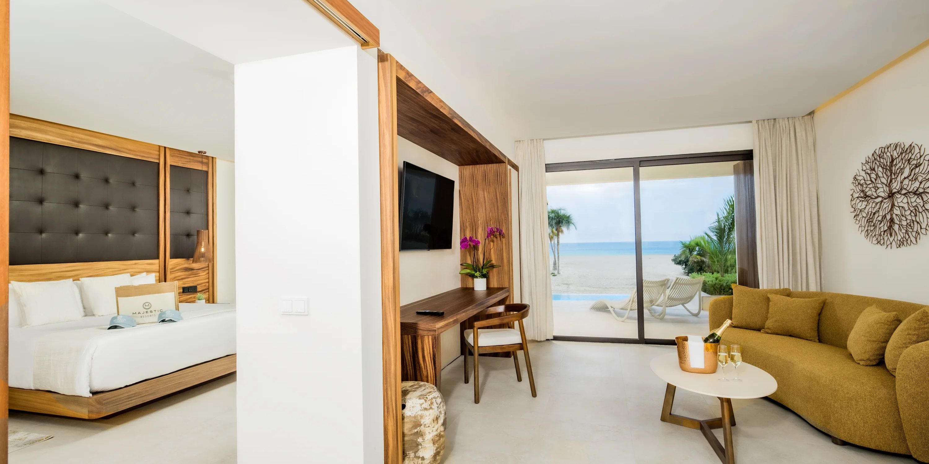 Modern suite featuring a bed, desk, and sofa&mdash;perfect for a destination wedding at Majestic Mirage.