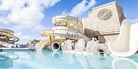 Spiral water slides and a stone structure at Majestic Mirage Costa Mujeres, an ideal wedding venue.