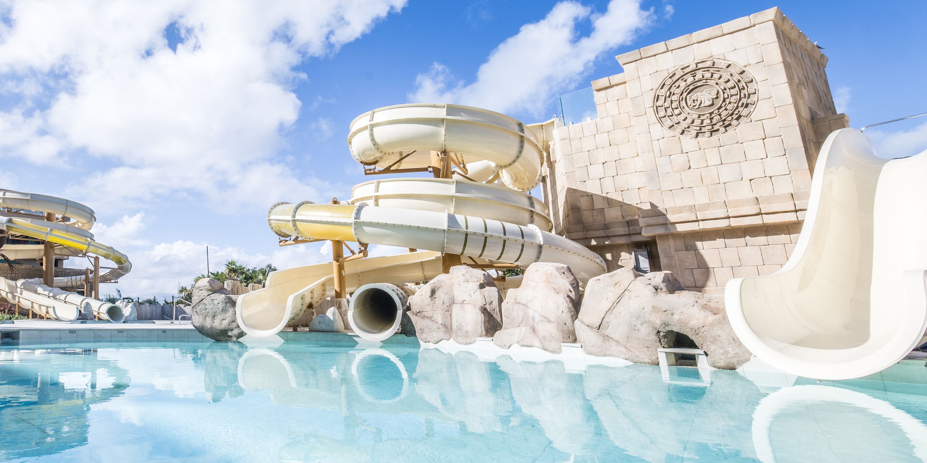 Large spiral slides and a pool near a temple, perfect for a destination wedding at Majestic Mirage Costa Mujeres.