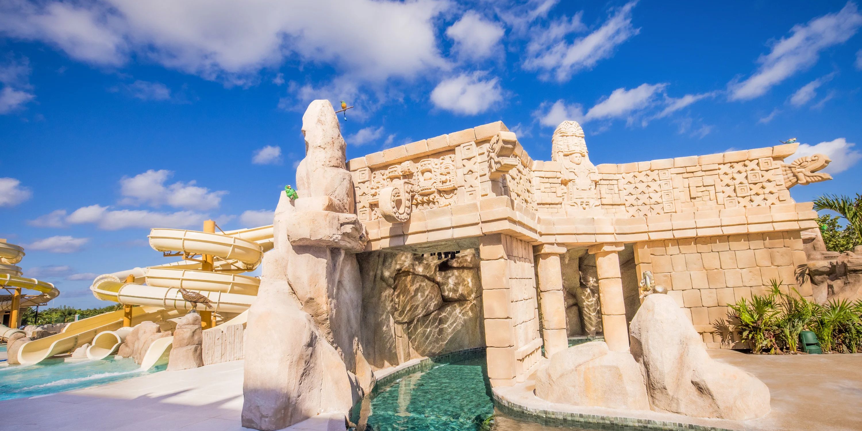 Mayan-themed water slide with stone carvings, perfect for a destination wedding at Majestic Mirage Costa Mujeres.
