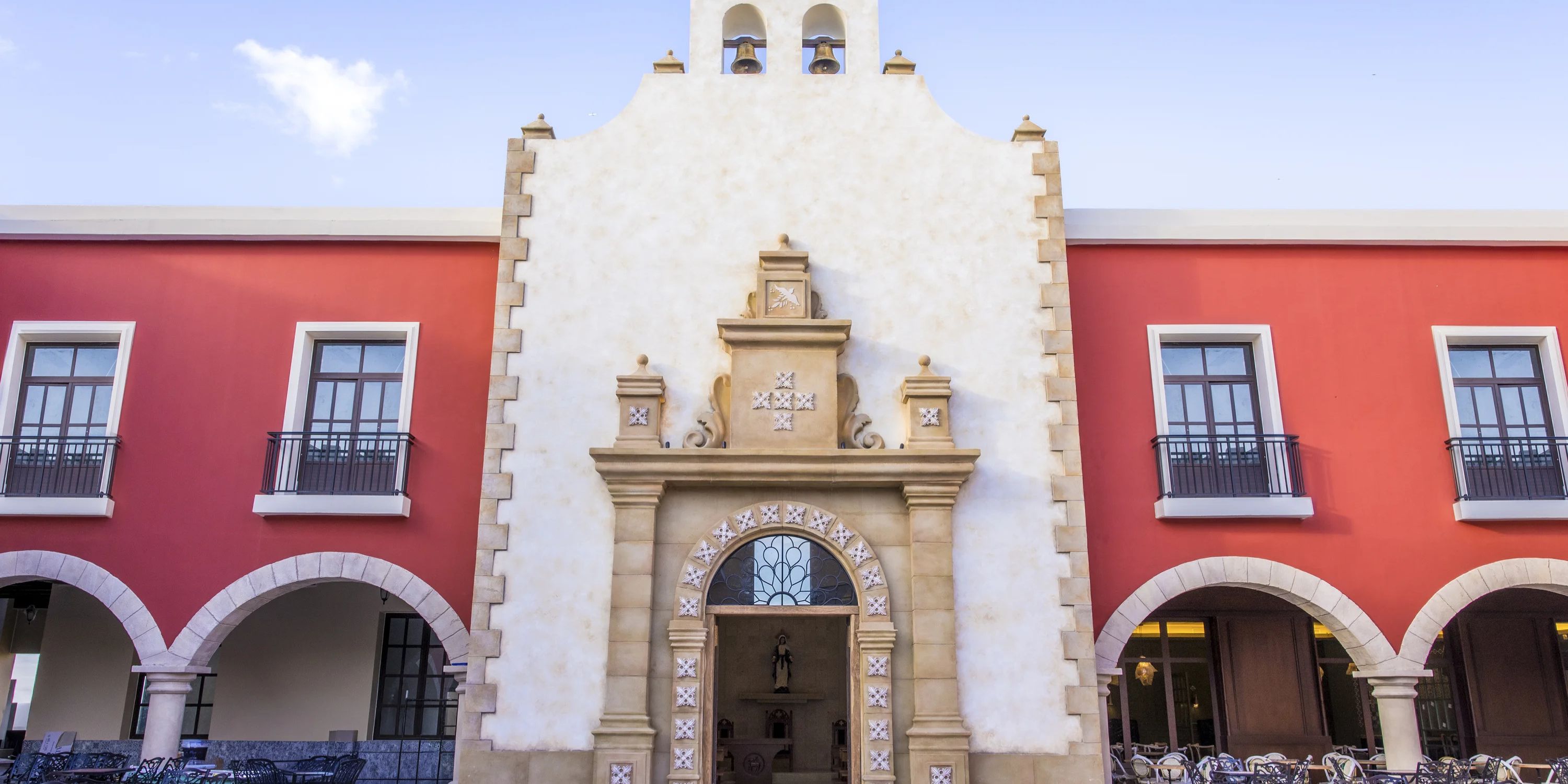 Front view of Majestic Mirage Costa Mujeres, an ideal destination wedding spot with white and red facade.